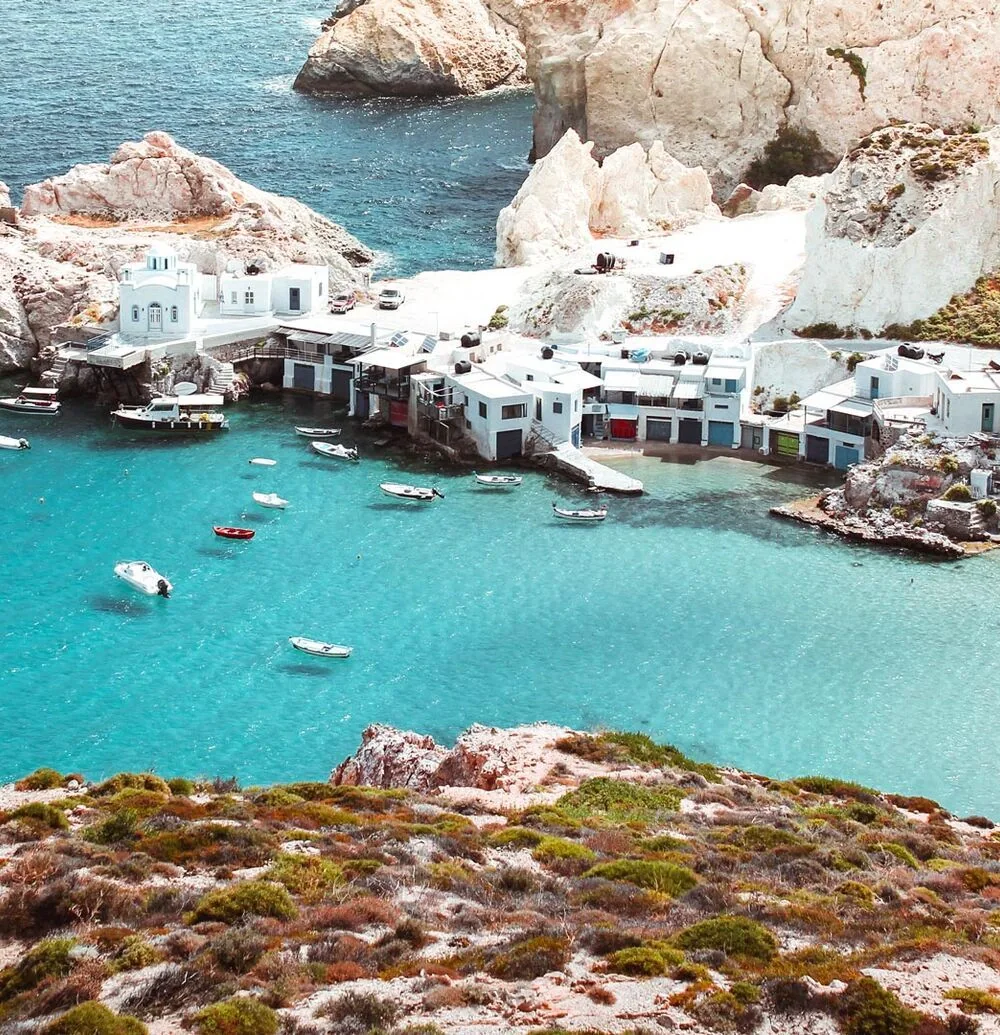 Milos adasının beyaz kayalıkları, turkuaz koyları ve Yunanistan'daki Kiklad köyü